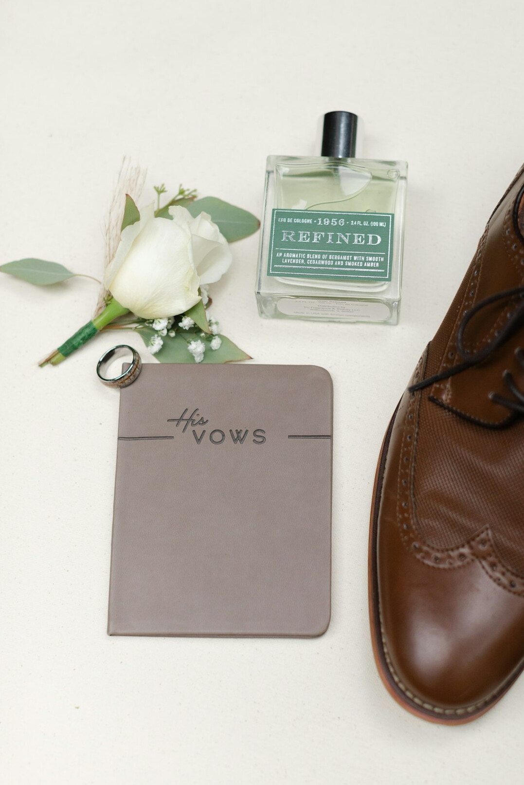 Hand writing notes in a notebook next to a laptop on a desk